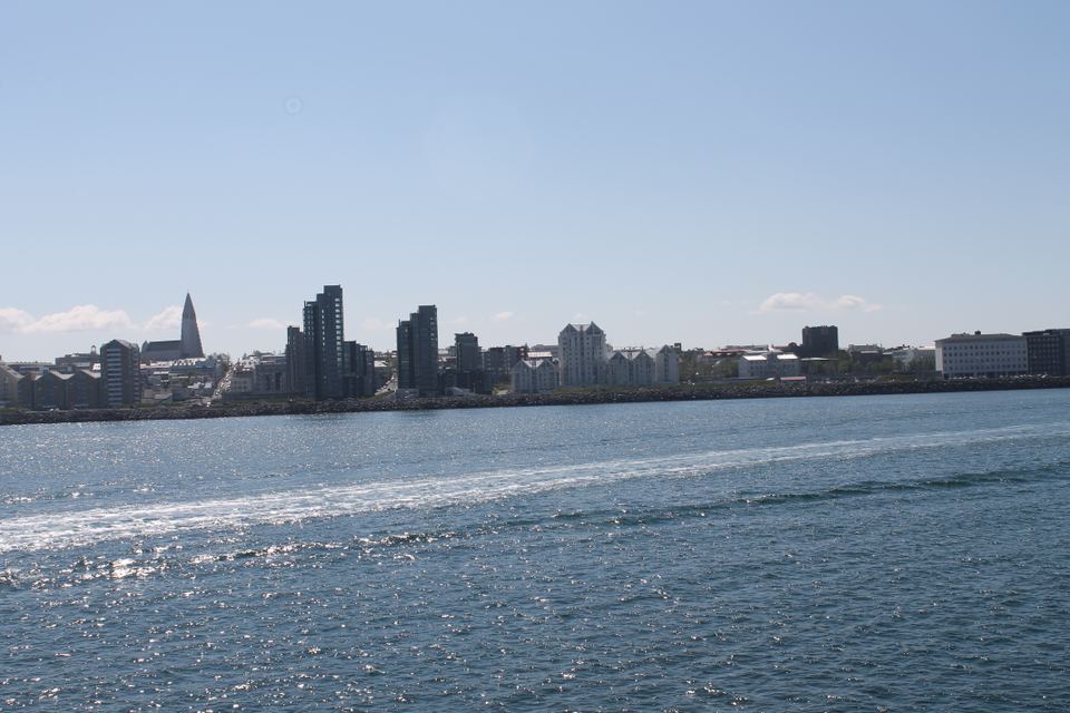 A view of the Reykjavik skyline and ocean water under a clear blue sky.