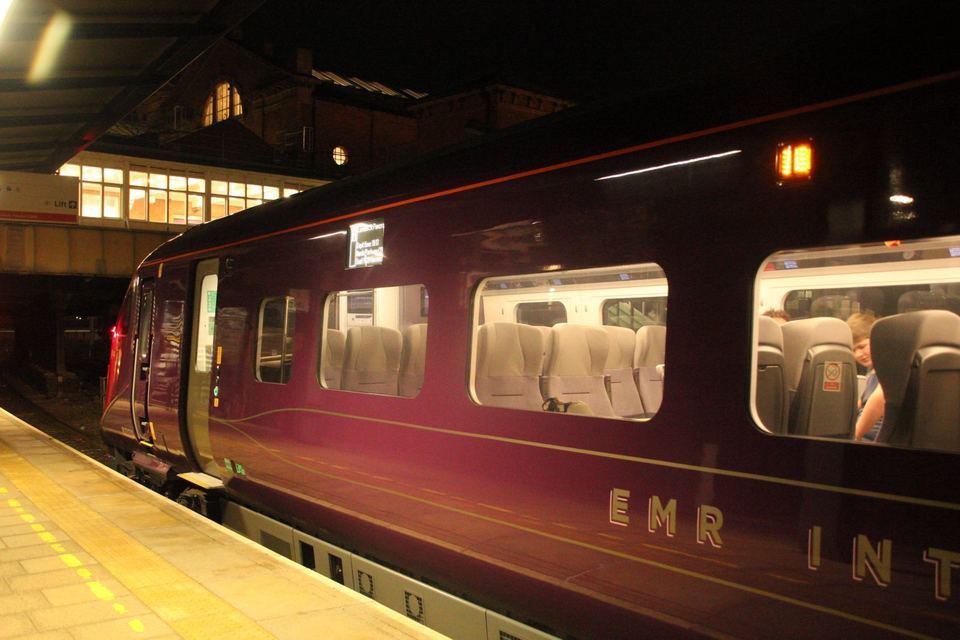 Exterior view of a purple train car parked at a station platform