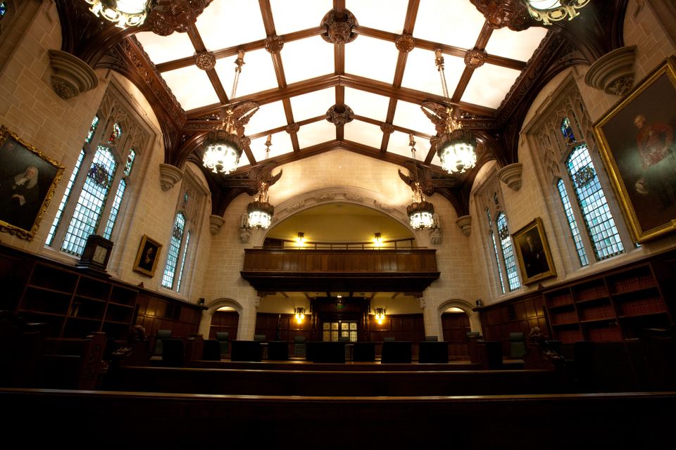 Grand interior hall with high timber ceilings, chandeliers, and stained glass windows