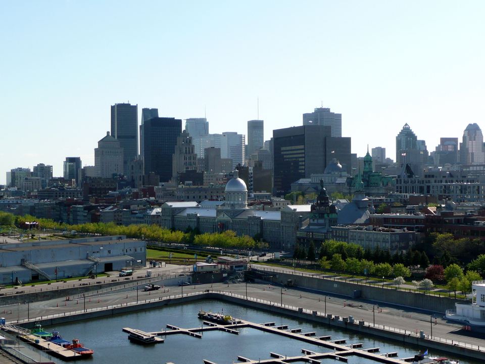 Wide panoramic view of the Montreal skyline and Old Port under a bright sky