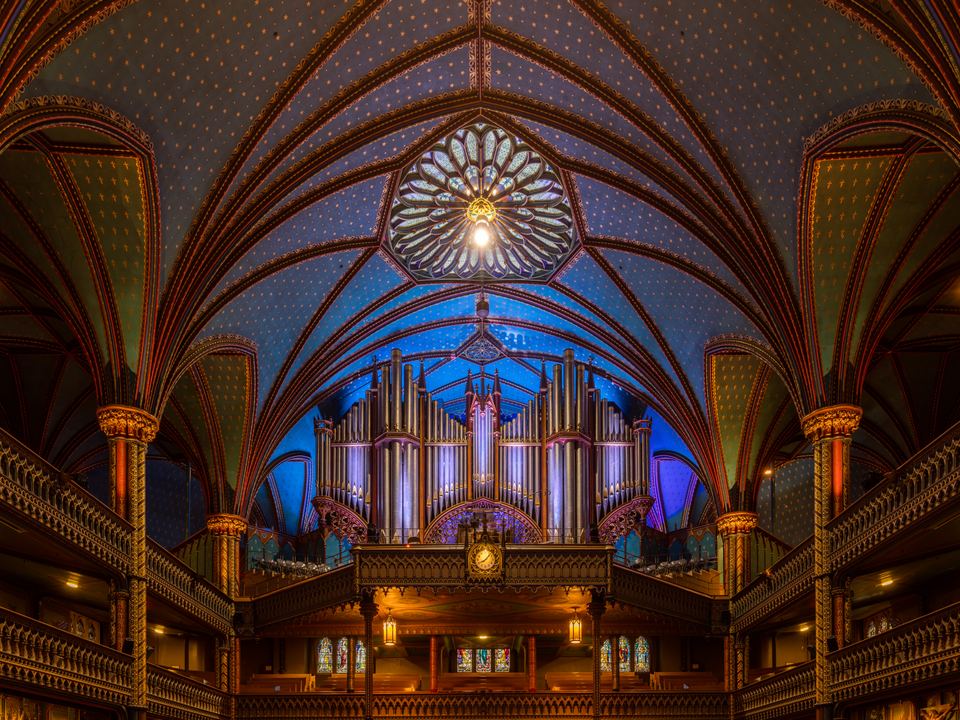 Intricate pipe organ and starry blue vaulted ceiling inside Notre-Dame Basilica
