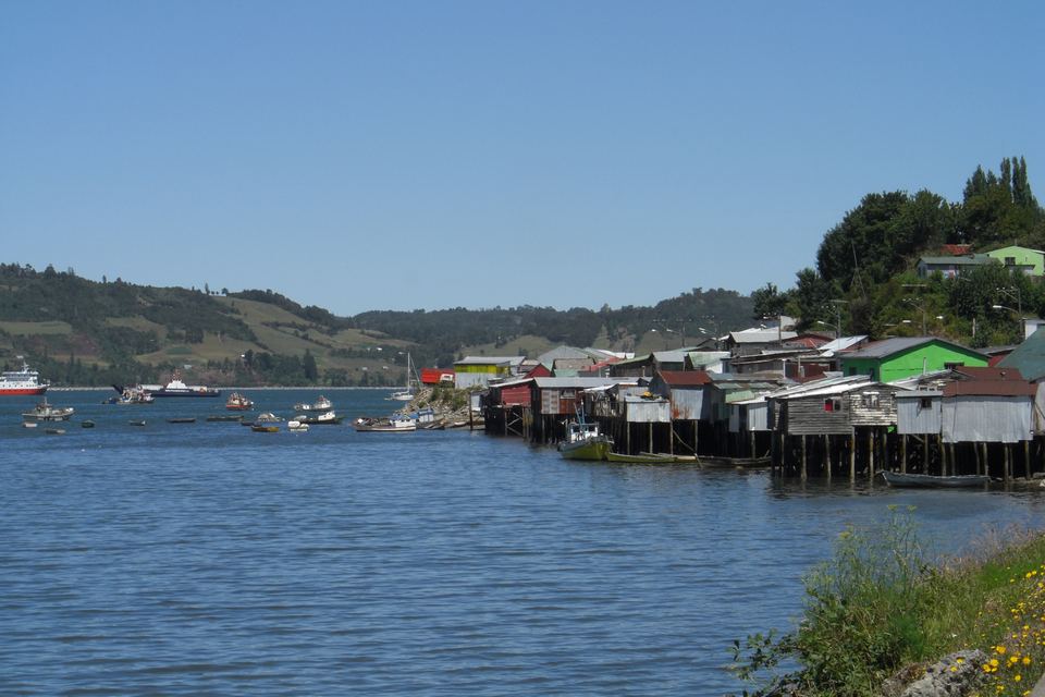 Colorful wooden stilt houses built along a wide bay in Chile