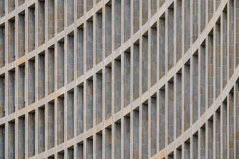 Close-up of a modern building facade with repeating rectangular window alcoves.