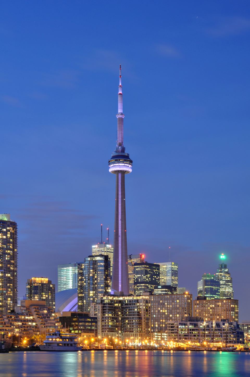 Vertical view of the brightly lit CN Tower and city skyline at night