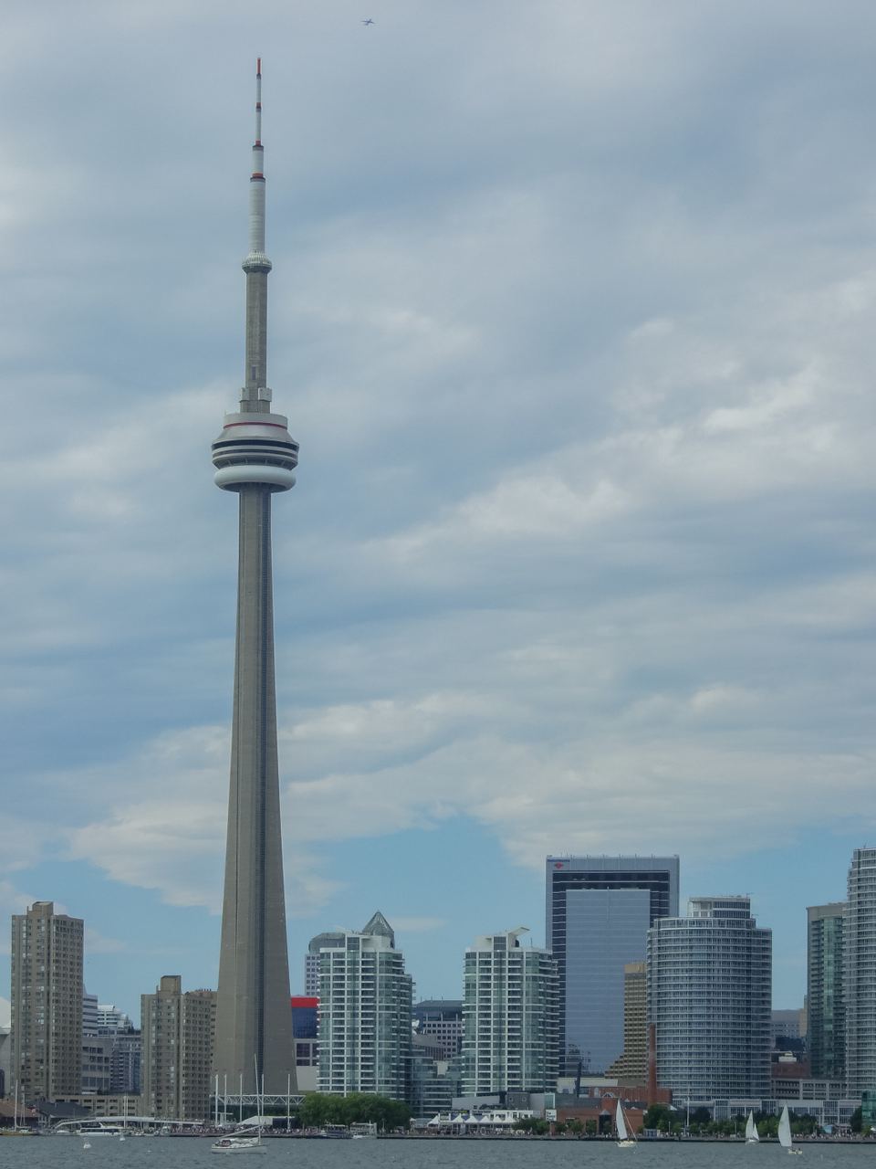 The CN Tower and city skyscrapers along the Toronto waterfront under a cloudy sky
