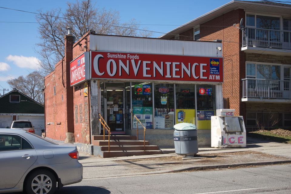 A small red-brick corner store with a large sign reading Sunshine Foods Convenience.