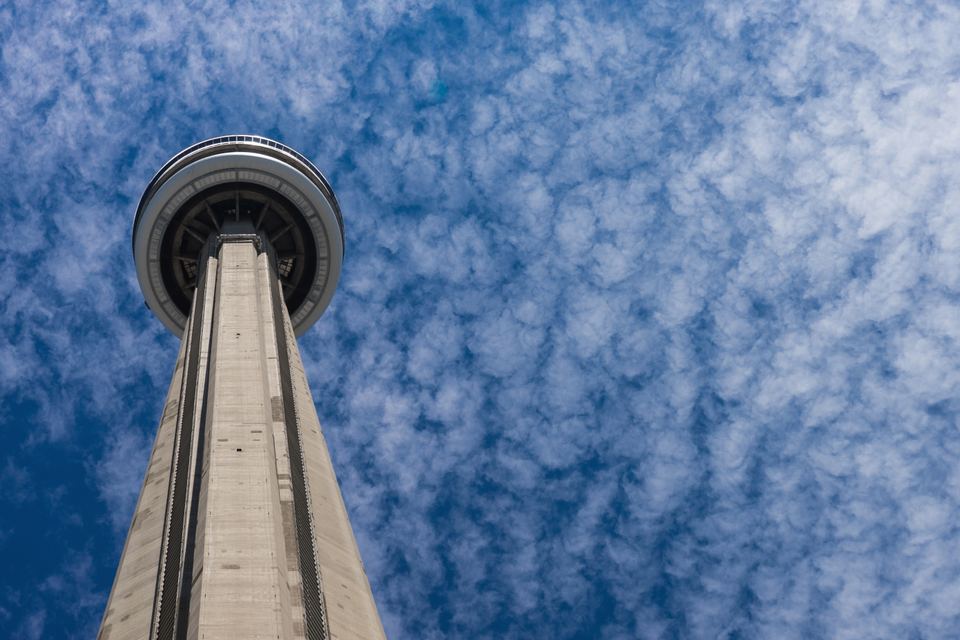 Dramatic low-angle view looking straight up at the CN Tower observation pod