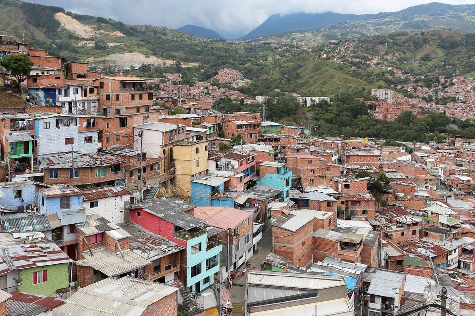 Brightly painted houses stacked up the hillside of Comuna 13, Medellin