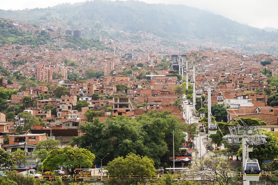 The Metrocable Linea K running up the valley above dense red-brick housing