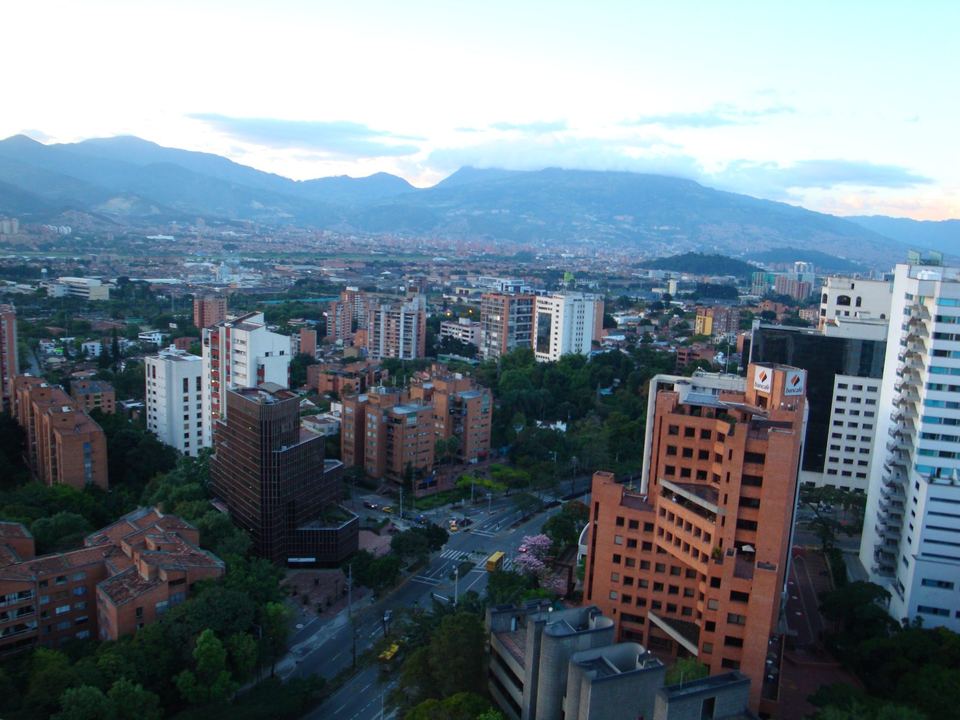 Medellin high-rises and red-brick neighbourhoods filling the green Aburra Valley