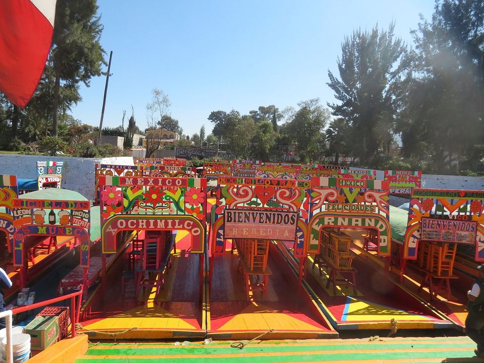 Brightly painted trajinera boats moored along a canal in Xochimilco