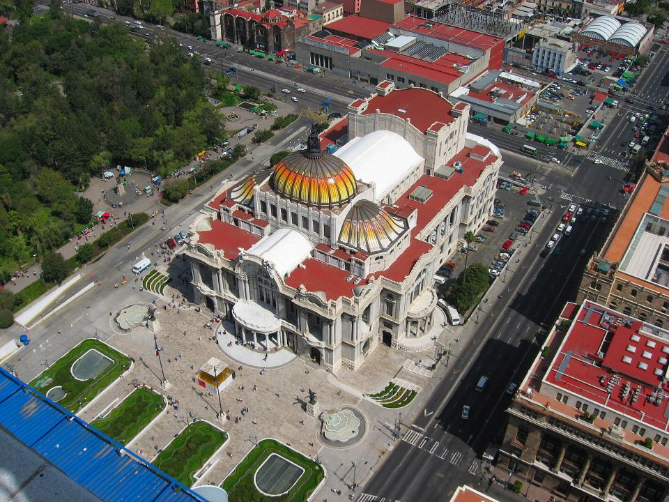 Aerial view of an ornate white marble building with a brightly colored yellow dome.