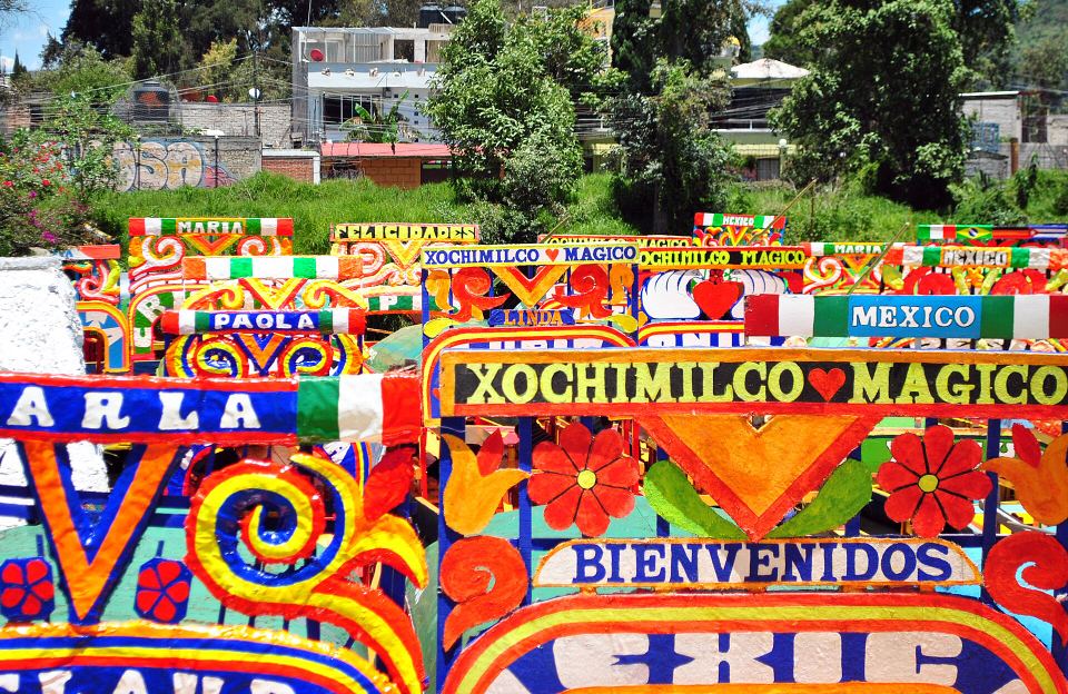 Close-up of vibrant, hand-painted wooden boat arches displaying colourful lettering.
