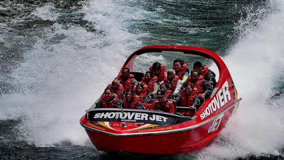A jet boat running through the narrow rock walls of the Shotover canyon.