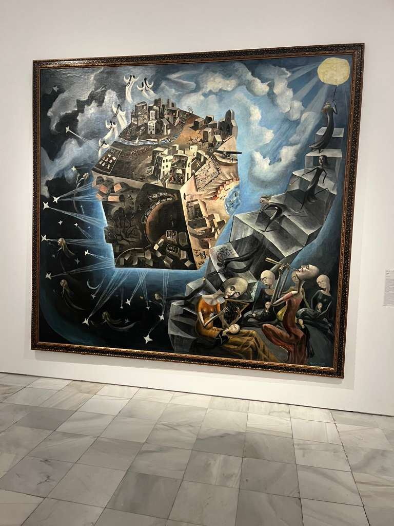 A large surrealist painting depicting floating figures and a cubed city hanging on a gallery wall.