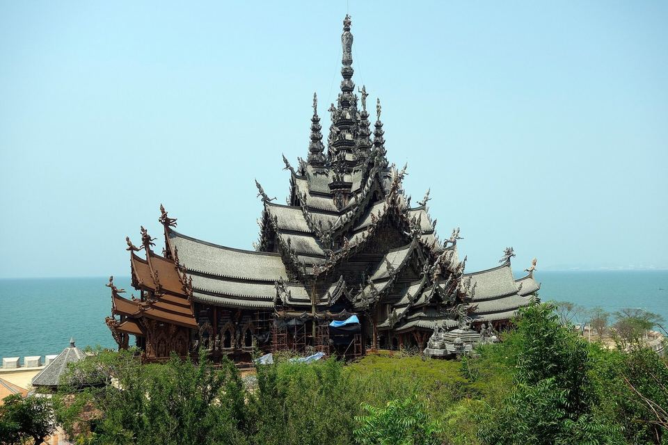 The carved teak spires of the Sanctuary of Truth rising above the trees on the Pattaya shoreline
