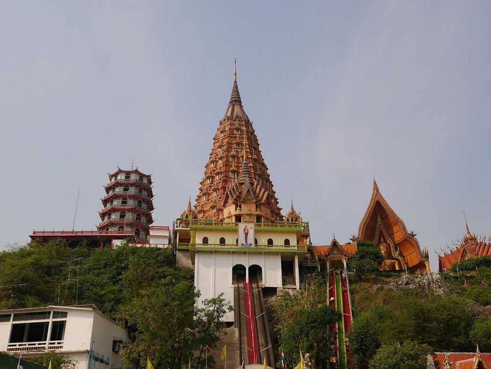 The tiered golden pagoda and hillside halls of Wat Tham Suea, the Tiger Cave Temple in Kanchanaburi